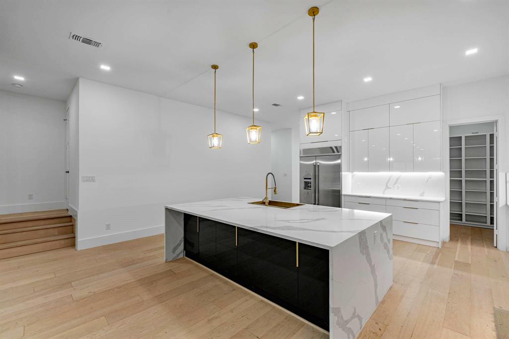 13032 Copenhill Road Dallas, TX 75240 - Photo 16 of 40 a large kitchen with kitchen island a sink stainless steel appliances and a counter top