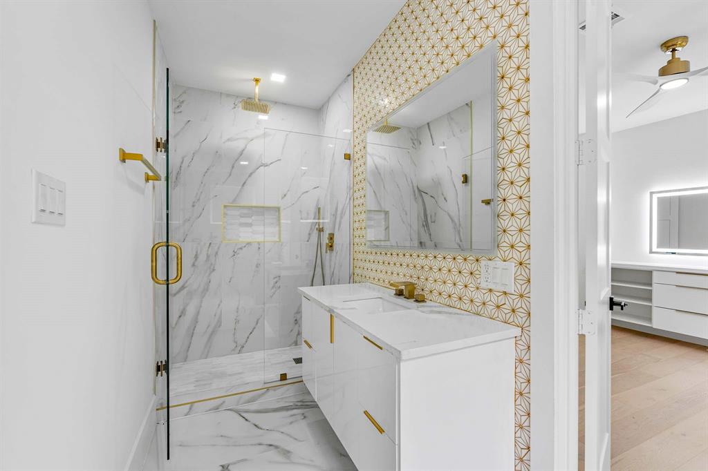 13032 Copenhill Road Dallas, TX 75240 - Photo 27 of 40 a bathroom with a sink a mirror and a shower