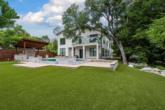 a front view of a house with swimming pool and porch with furniture
