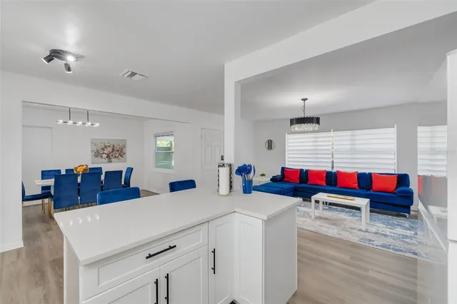 a kitchen with stainless steel appliances kitchen island granite countertop a sink dining table and chairs