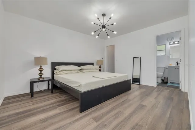 a spacious bedroom with a bed and a chandelier