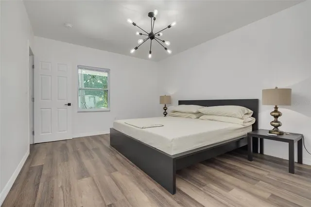 a bedroom with a bed and a chandelier