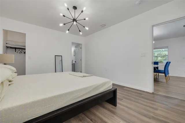 a bedroom with a large bed and a chandelier