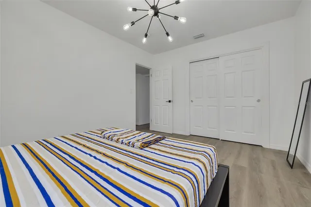 a bedroom with a bed and a chandelier