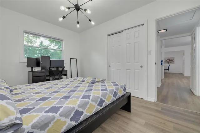 a bedroom with a bed and a chandelier