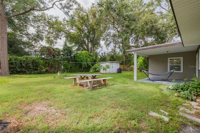 a backyard of a house with table and chairs