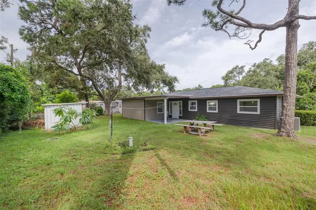 a front view of a house with a garden and trees