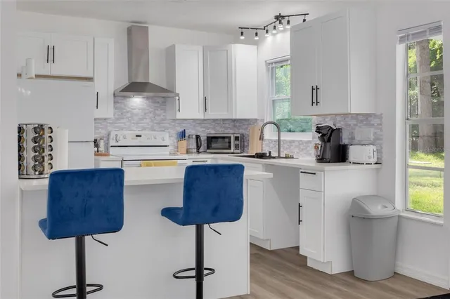 a kitchen with stainless steel appliances granite countertop a sink a stove and a cabinets