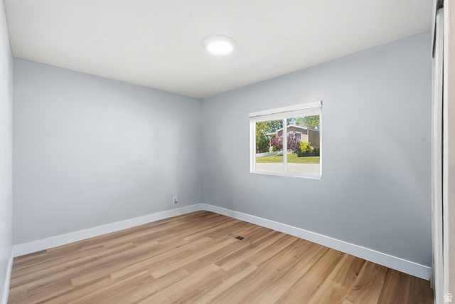 2500 North Fort Lane, Unit 220 Layton, UT 84041 - Photo 17 of 23 Spacious room featuring wood-finish flooring, light blue wall paint, white trim, and a window with white blinds