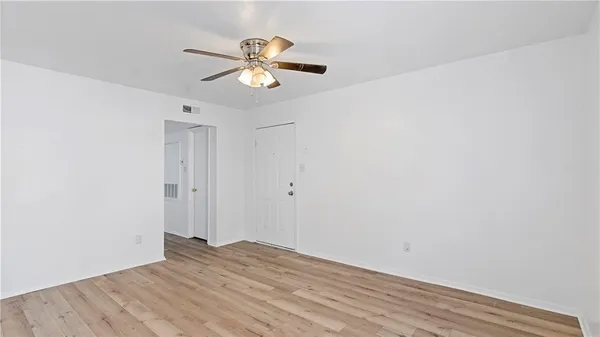 an empty room with a window and a fan