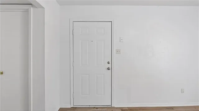 a view of empty room with wooden floor and ceiling fan