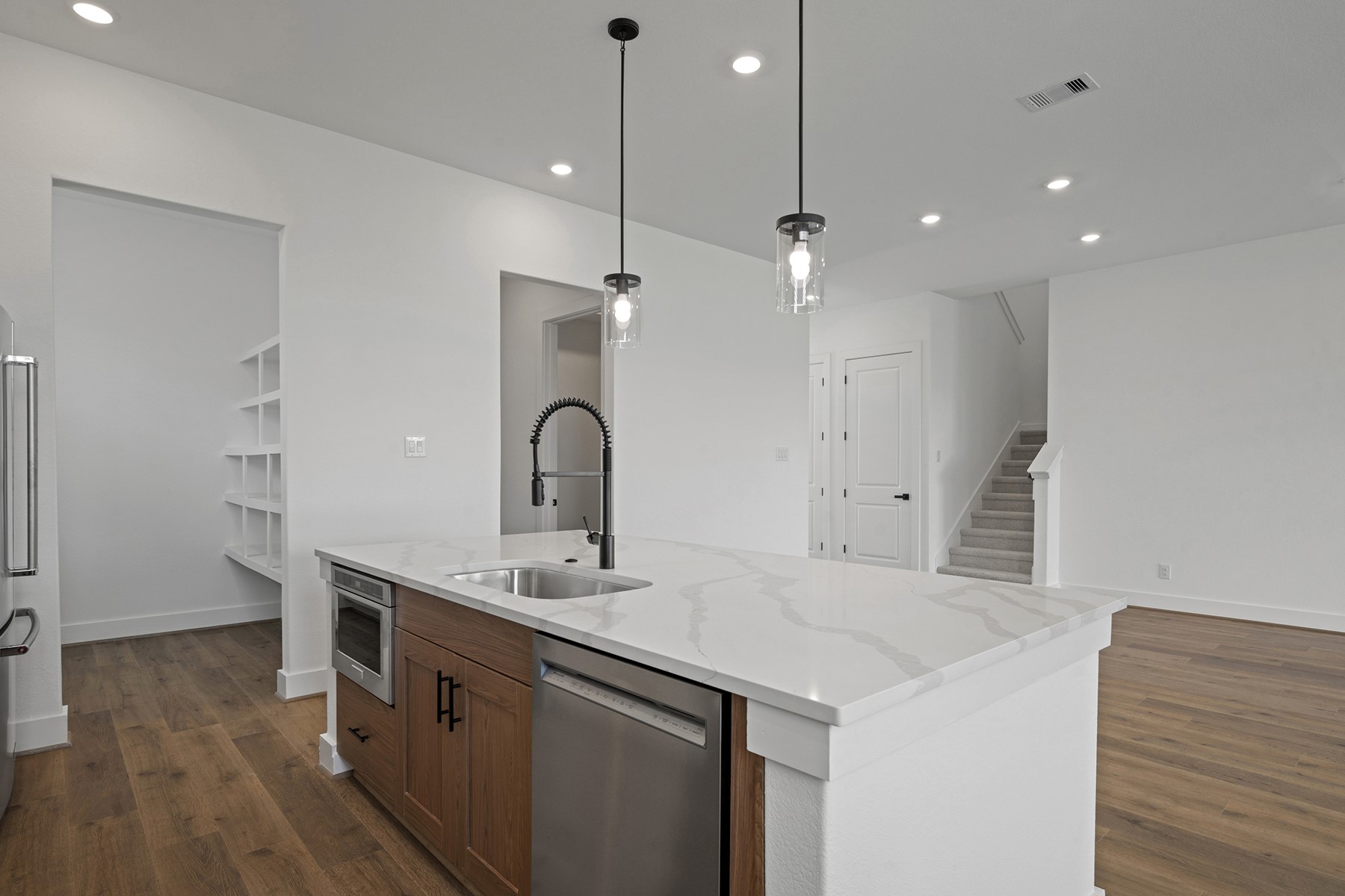 1805 Drover Lane Rosenberg, TX 77471 - Photo 12 of 29 a kitchen with a sink a chandelier stainless steel appliances and cabinets