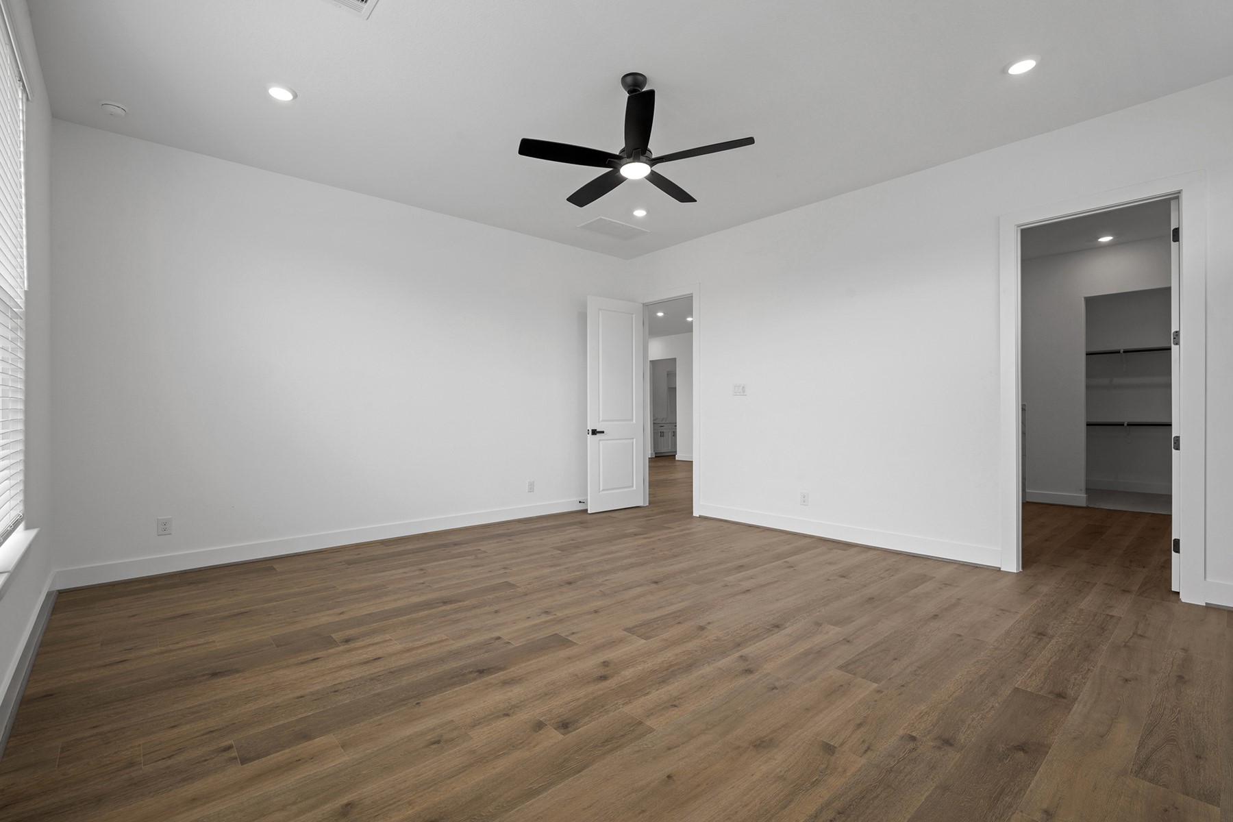 1805 Drover Lane Rosenberg, TX 77471 - Photo 20 of 29 an empty room with wooden floor ceiling fan and windows