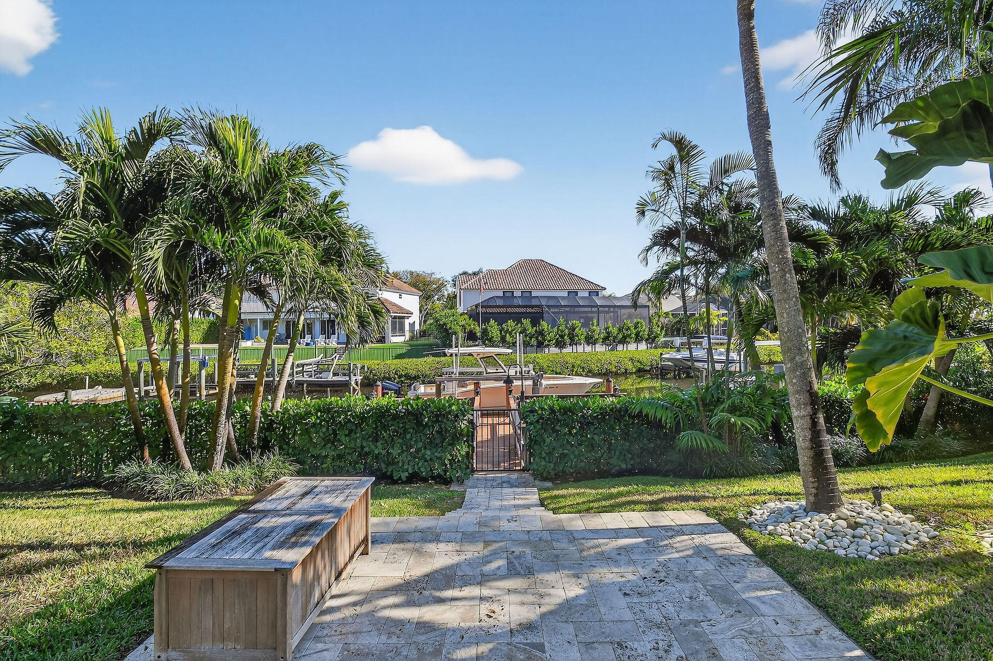 19954 Loxahatchee Pointe Drive Jupiter, FL 33458 - Photo 49 of 60 a view of a patio with table and chairs potted plants and palm tree