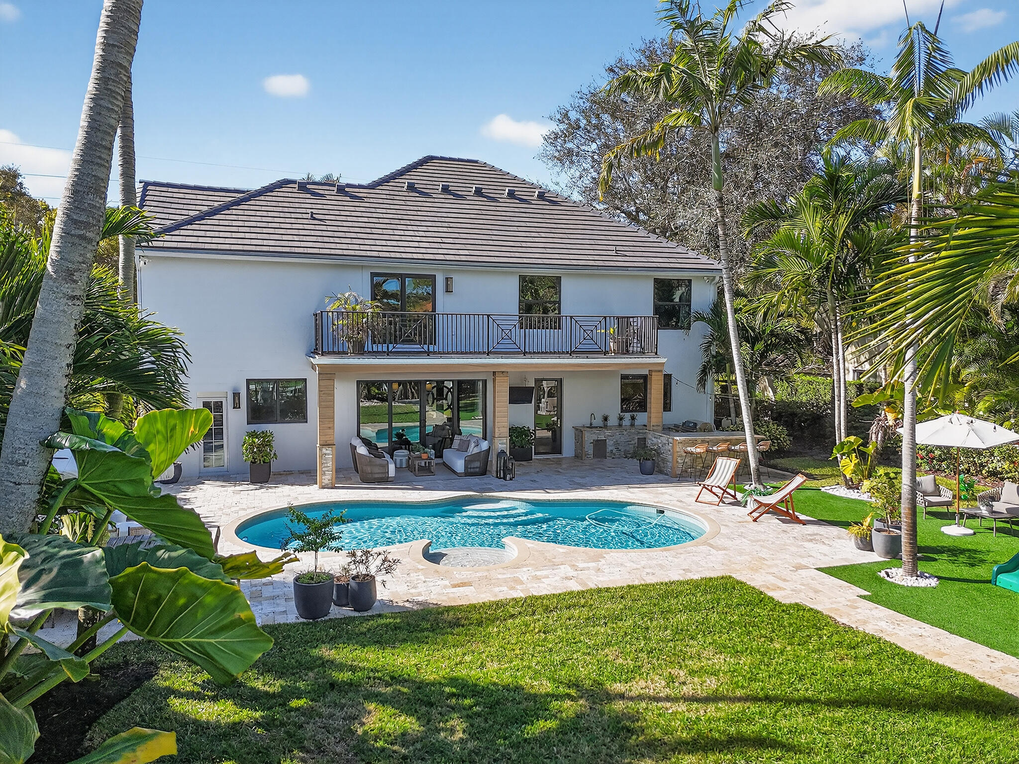 19954 Loxahatchee Pointe Drive Jupiter, FL 33458 - Photo 53 of 60 a front view of a house with garden and sitting area