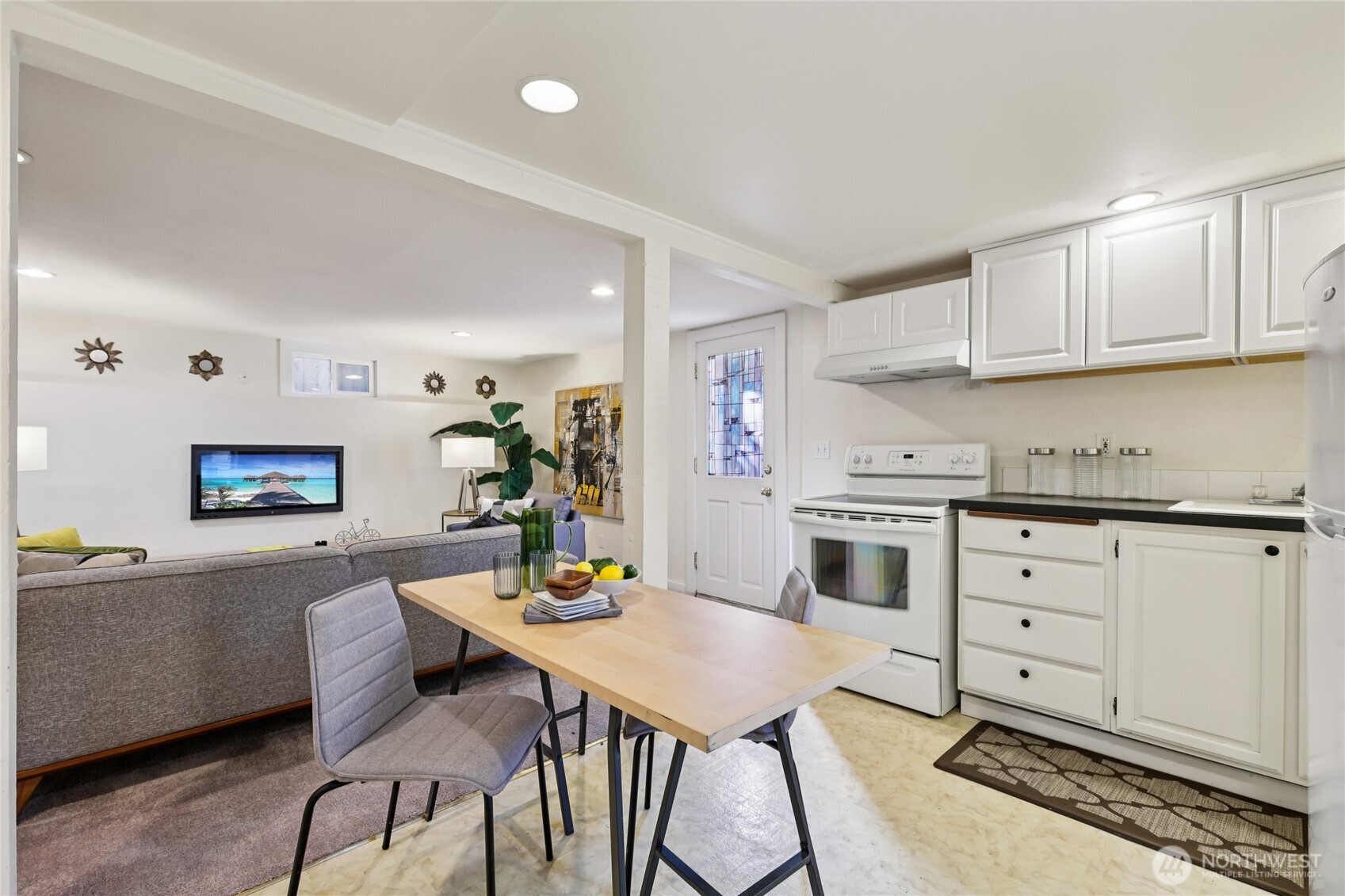 511 23rd Avenue East Seattle, WA 98112 - Photo 34 of 39 a kitchen with stainless steel appliances kitchen island granite countertop a dining table chairs and a refrigerator