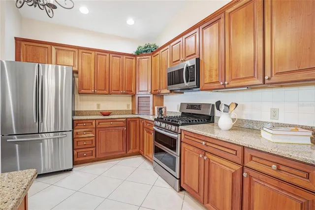 a large kitchen with kitchen island granite countertop a stove a sink a dining table and chairs