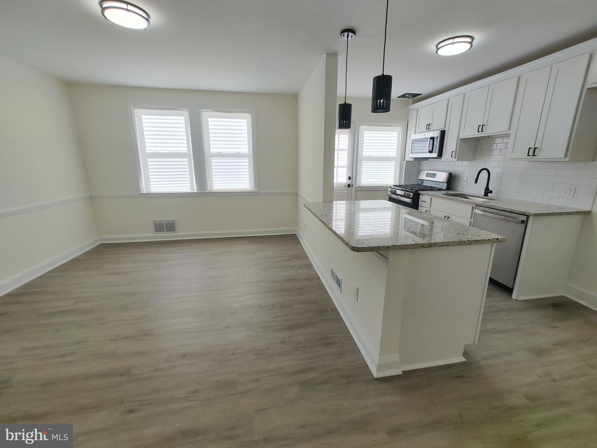 1525 Medford Road Baltimore, MD 21218 - Photo 12 of 39 a kitchen with kitchen island granite countertop a sink stove and cabinets