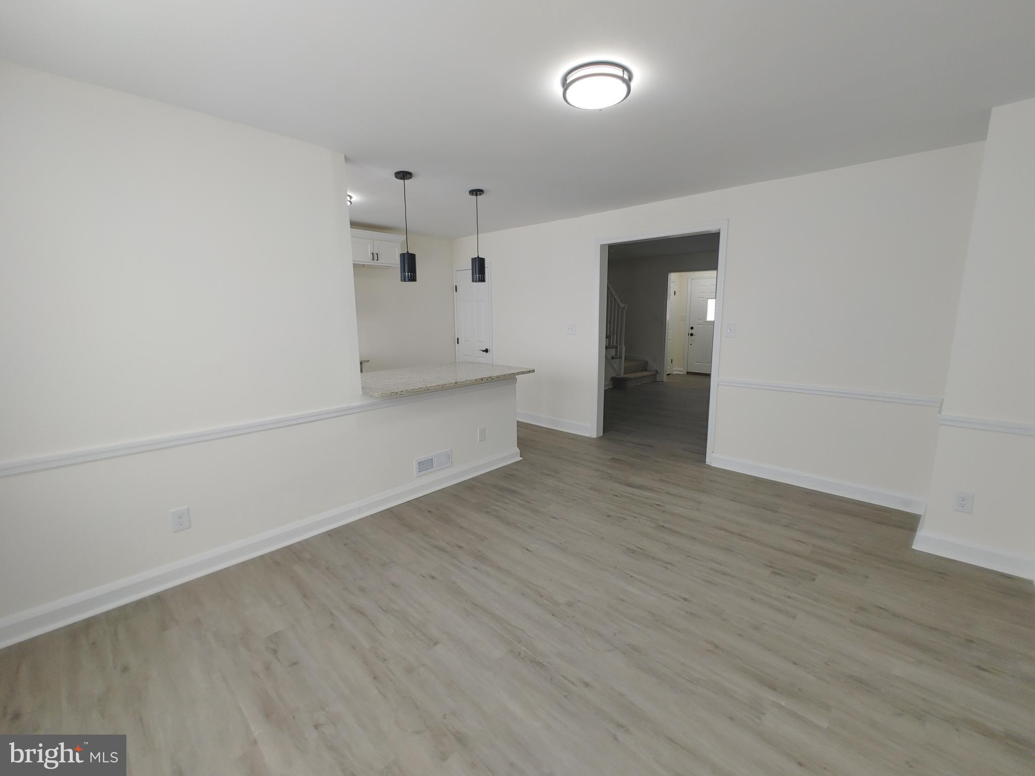 1525 Medford Road Baltimore, MD 21218 - Photo 16 of 39 an empty room with wooden floor and white walls