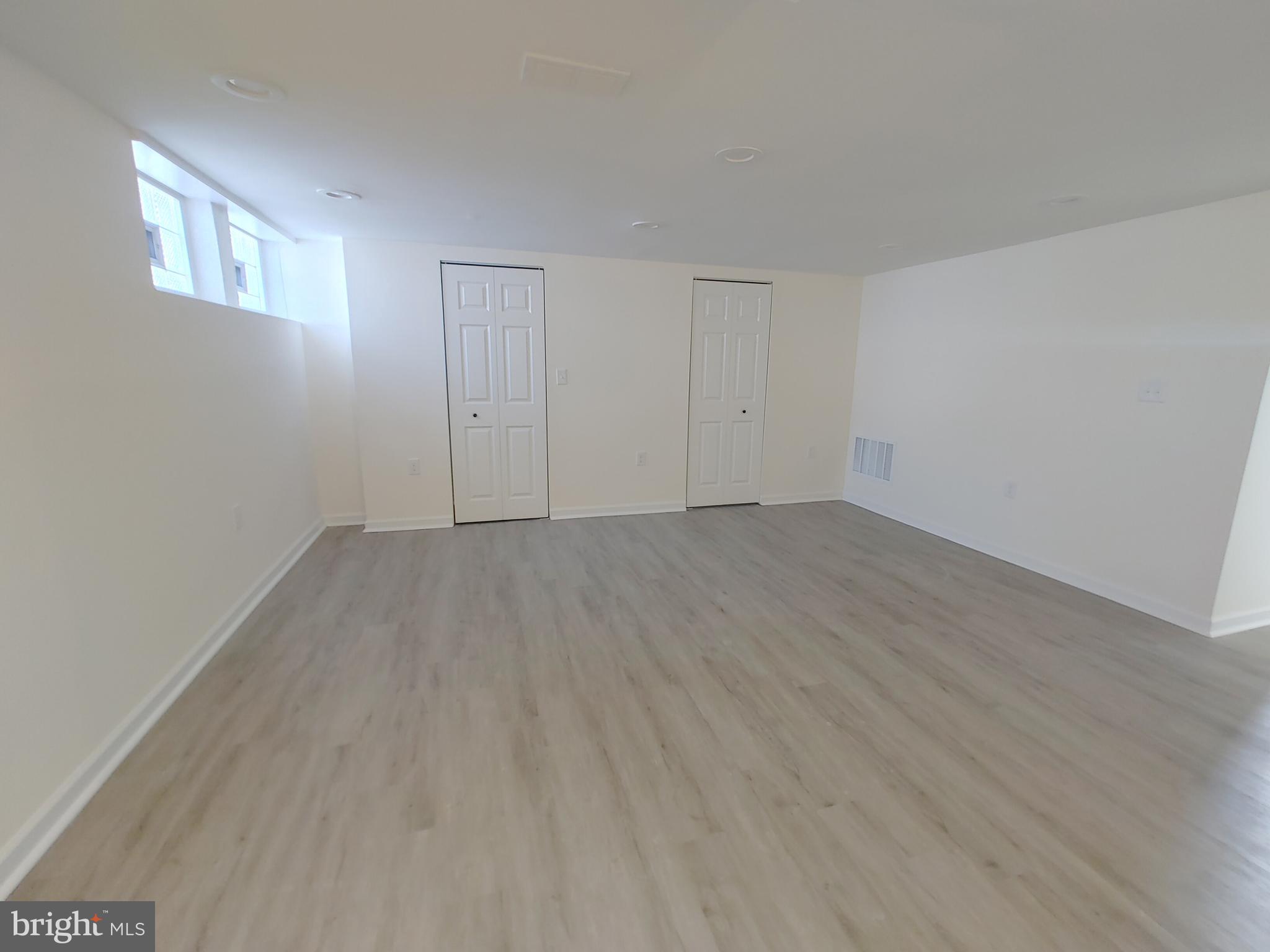 1525 Medford Road Baltimore, MD 21218 - Photo 35 of 39 a view of an empty room with wooden floor and a window