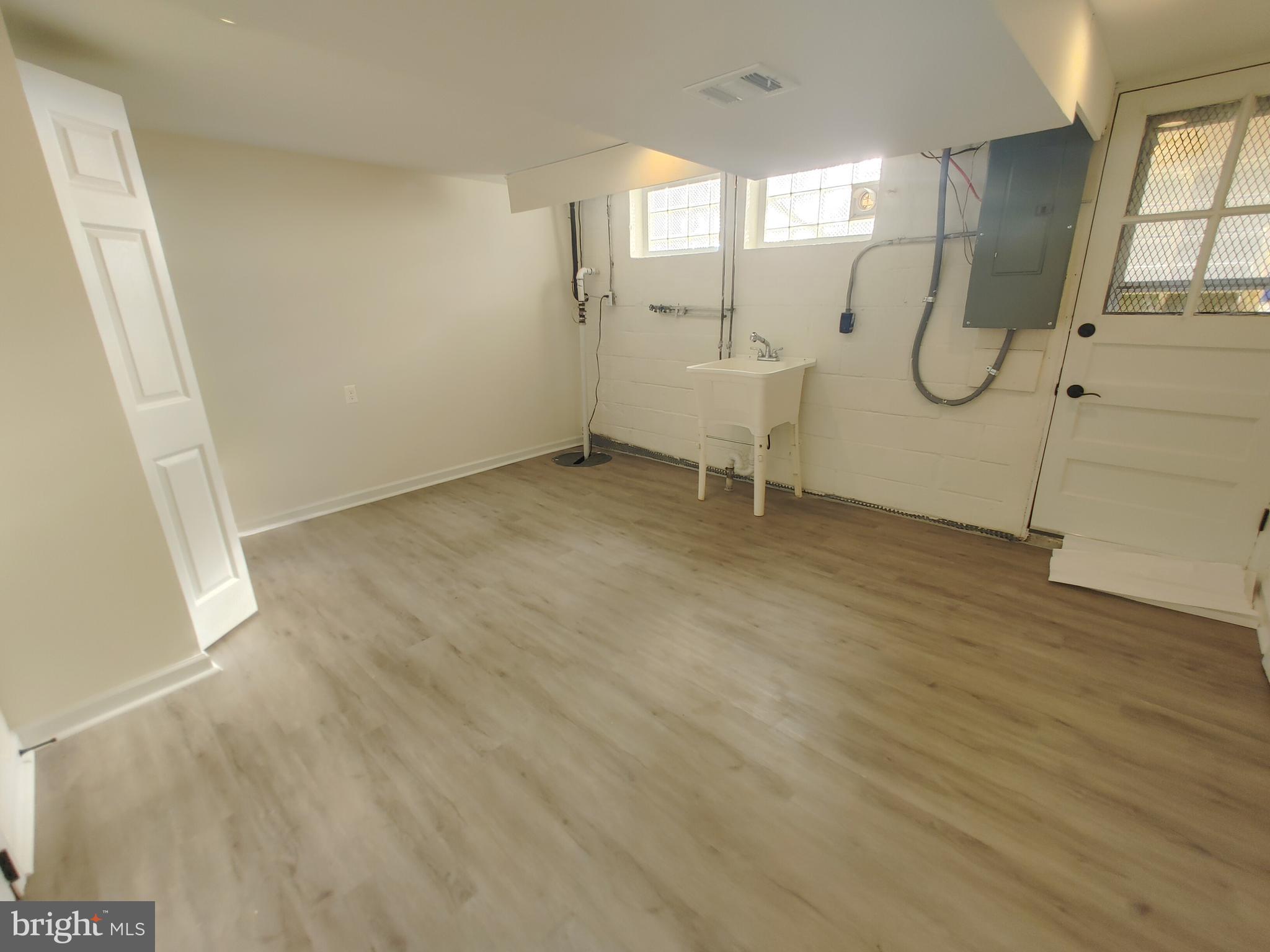 1525 Medford Road Baltimore, MD 21218 - Photo 36 of 39 an empty room with wooden floor and white walls