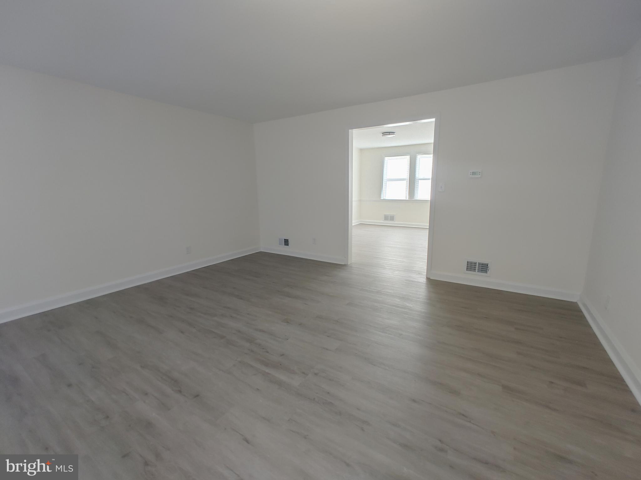 1525 Medford Road Baltimore, MD 21218 - Photo 9 of 39 a view of an empty room with wooden floor and a window