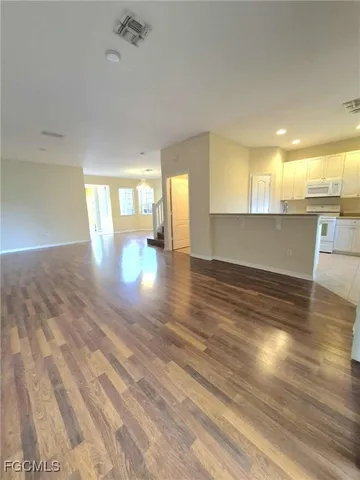 a view of empty room with wooden floor and windows