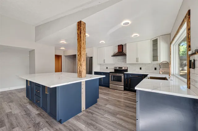 a kitchen with stainless steel appliances kitchen island a large counter top and a stove