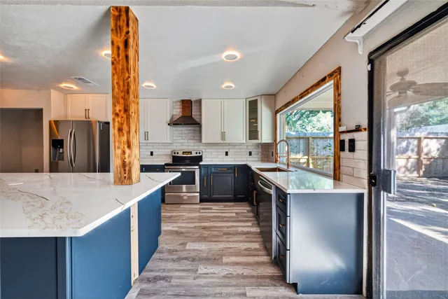 a kitchen with stainless steel appliances granite countertop sink stove and refrigerator