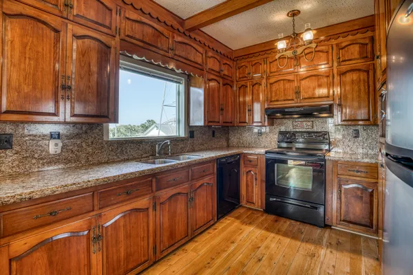 a kitchen with stainless steel appliances granite countertop a stove a sink and a microwave
