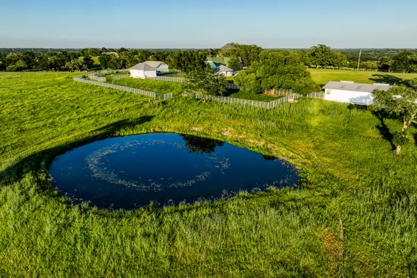 a view of a water pond with green yard