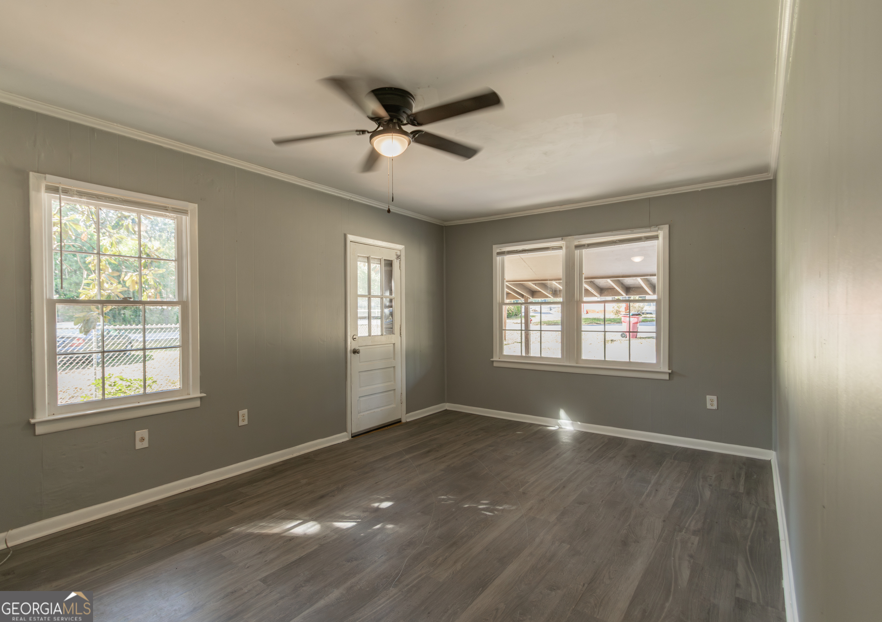 208 Bassett Street Centerville, GA 31028 - Photo 11 of 24 a view of an empty room with a window and wooden floor