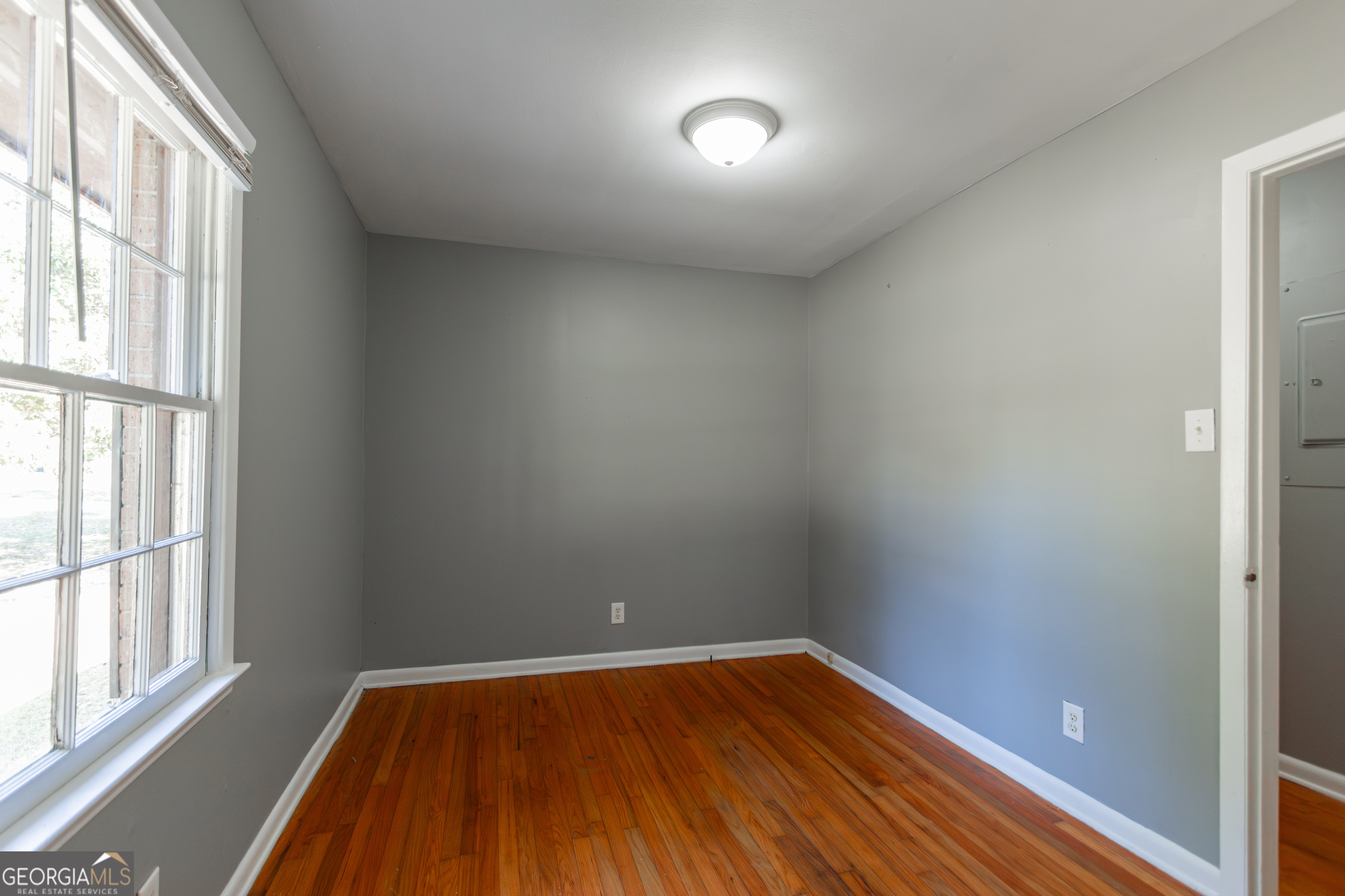 208 Bassett Street Centerville, GA 31028 - Photo 15 of 24 a view of an empty room with wooden floor and a window
