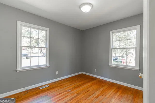 a view of a room with wooden floor and windows