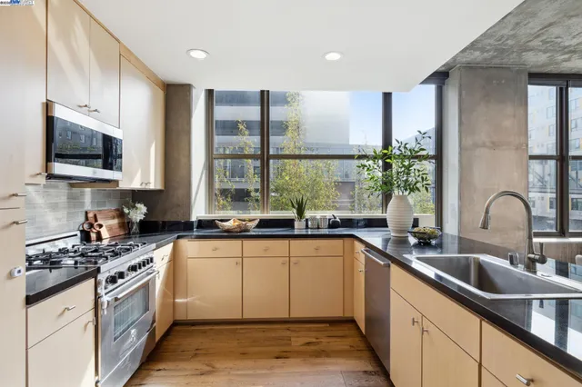 a kitchen with a sink a counter top space cabinets and stainless steel appliances