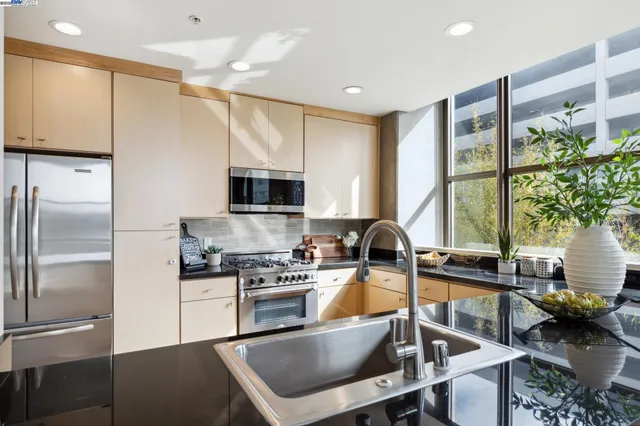a kitchen with kitchen island granite countertop a stove refrigerator and sink