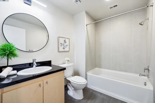 a bathroom with a granite countertop sink a toilet and a mirror