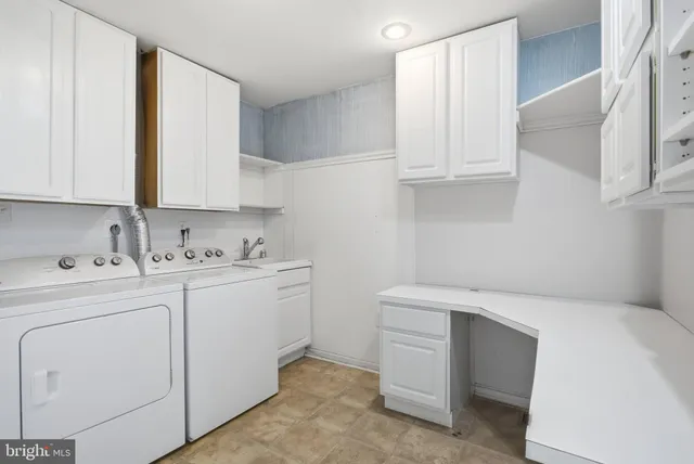a utility room with cabinets washer and dryer
