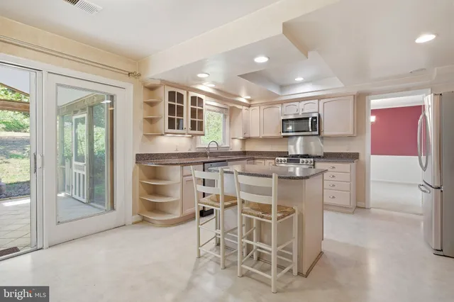 a kitchen with kitchen island a counter top space appliances and a cabinets