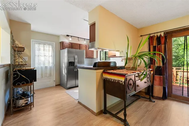 a kitchen with stainless steel appliances granite countertop a sink and a refrigerator