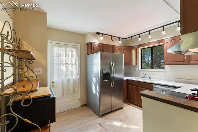 a kitchen with stainless steel appliances granite countertop a stove a sink and a refrigerator