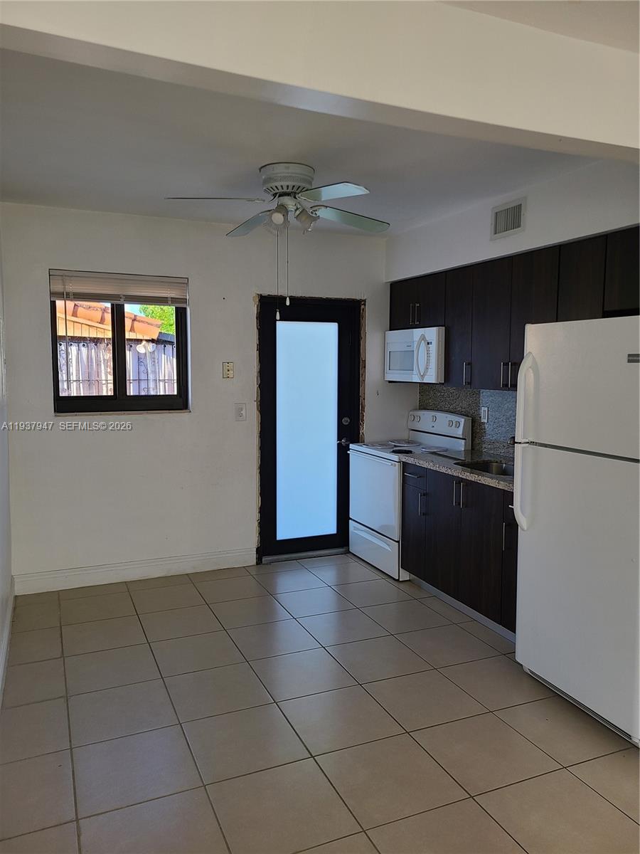 310-312 Southwest 36th Avenue Miami, FL 33135 - Photo 12 of 15 a kitchen with stainless steel appliances a refrigerator and a stove top oven