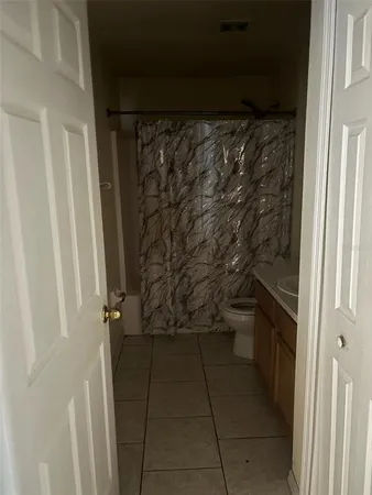 a bathroom with a granite countertop shower and a sink