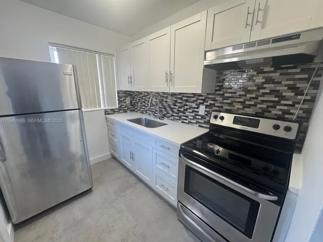 a kitchen with granite countertop a refrigerator and a stove