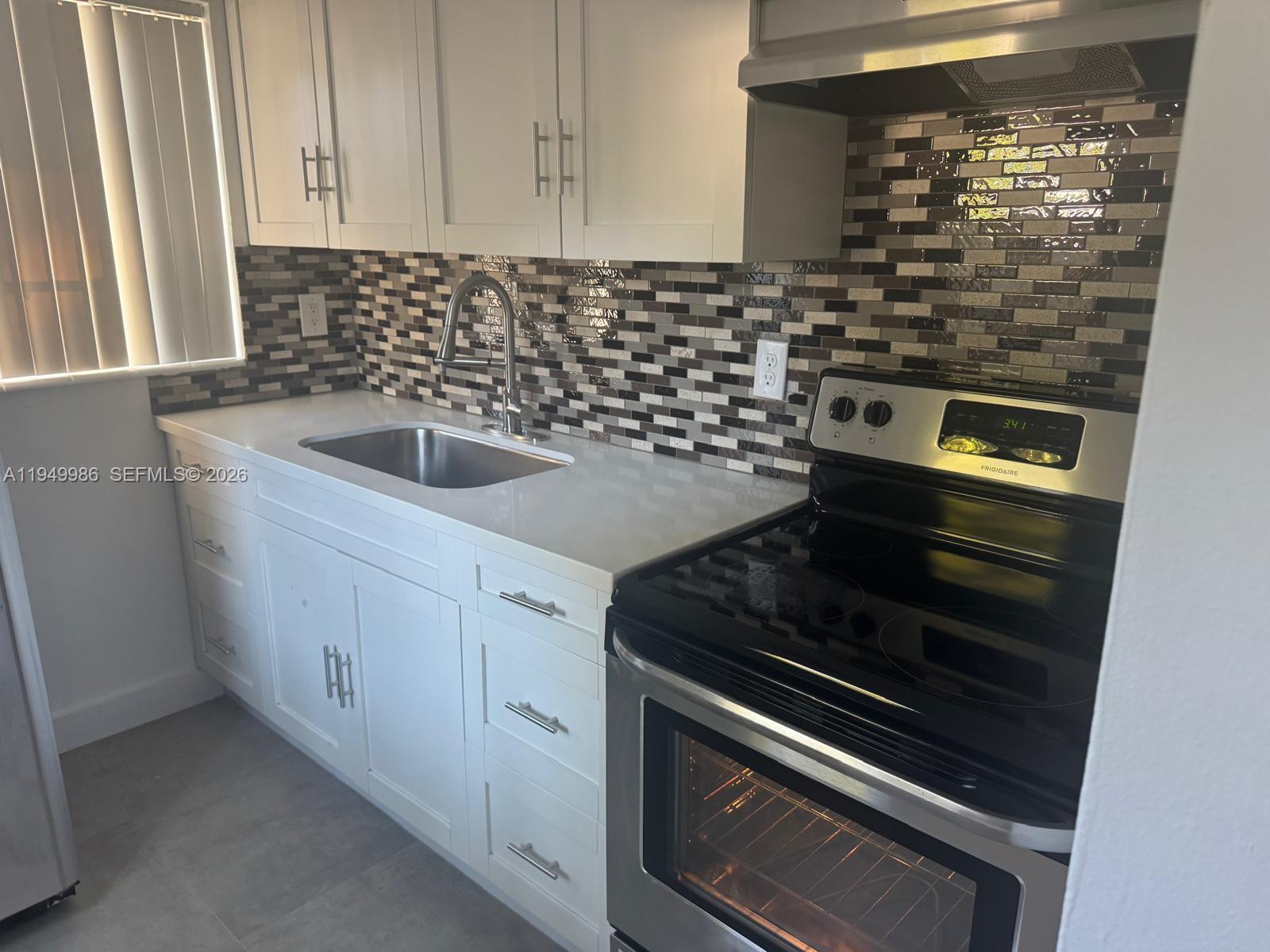 1631 Rodman Street, Unit 1631 Hollywood, FL 33020 - Photo 2 of 7 a kitchen with granite countertop a stove and a sink