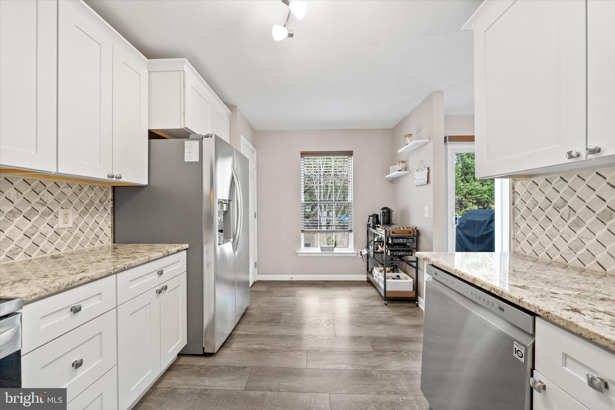 337 Norman Drive Newark, DE 19702 - Photo 13 of 33 a kitchen with a sink dishwasher a stove and white cabinets with wooden floor