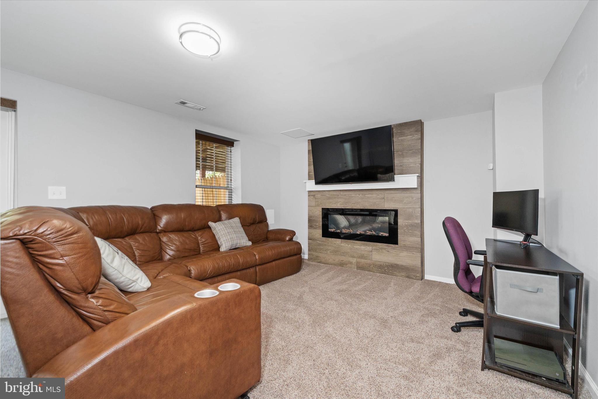 337 Norman Drive Newark, DE 19702 - Photo 26 of 33 a living room with furniture a flat screen tv and a fireplace