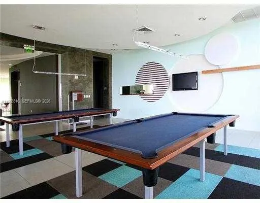 a room with furniture pool table and mirror