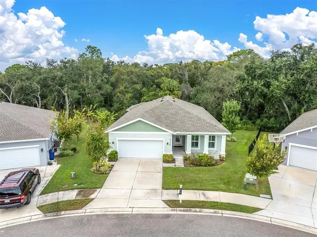 a front view of a house with a yard and trees