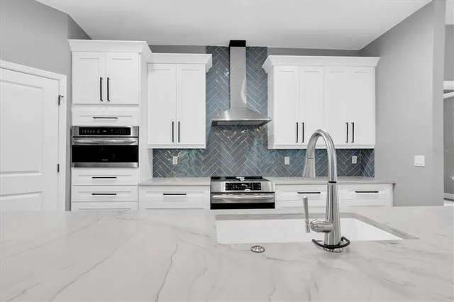 a large kitchen with kitchen island a sink stainless steel appliances and cabinets